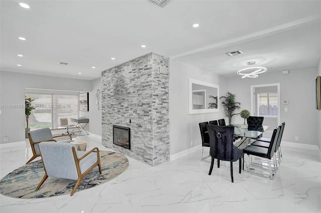 dining space with a stone fireplace and a wealth of natural light