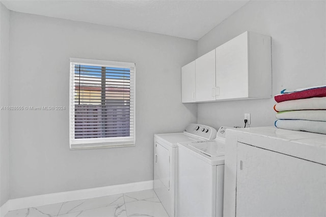 laundry room with washer and clothes dryer and cabinets