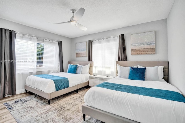 bedroom featuring ceiling fan, a textured ceiling, and wood-type flooring