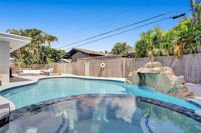 view of pool featuring pool water feature and an in ground hot tub