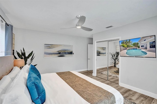 bedroom with ceiling fan, wood-type flooring, and a closet