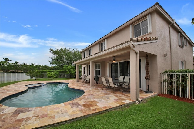 rear view of house with a patio, a fenced in pool, and ceiling fan