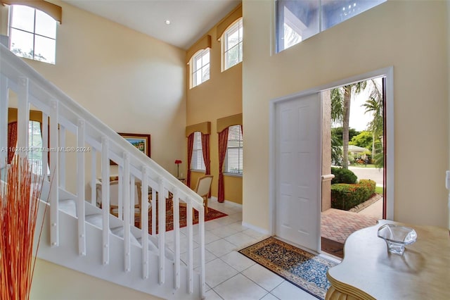 tiled entryway featuring plenty of natural light and a high ceiling