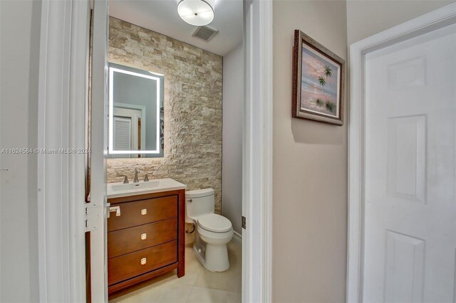 bathroom with tile patterned flooring, tile walls, toilet, and vanity