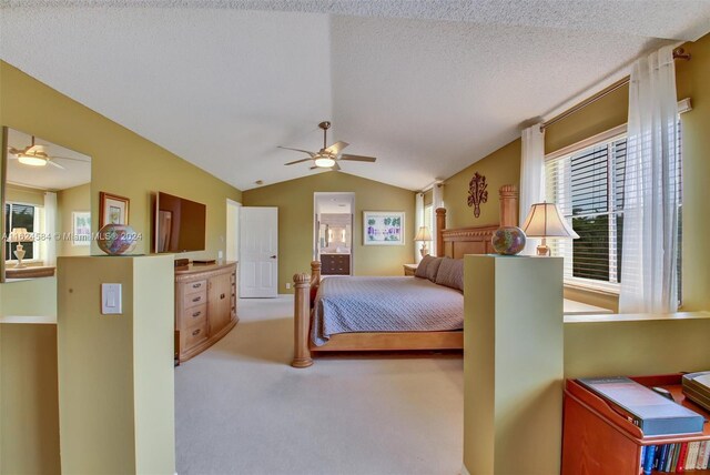 carpeted bedroom with multiple windows, a textured ceiling, ceiling fan, and vaulted ceiling