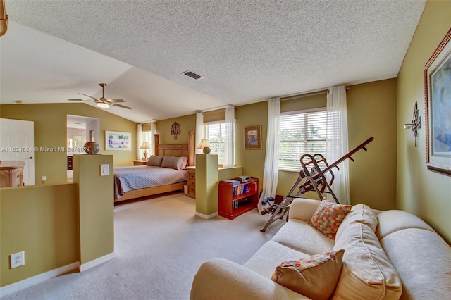 bedroom with light carpet, ceiling fan, vaulted ceiling, and a textured ceiling