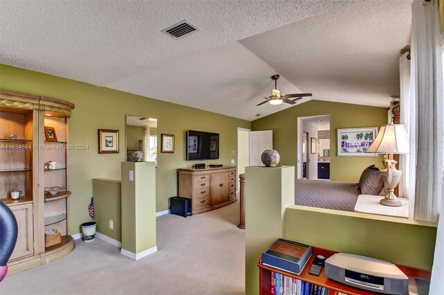 interior space with a textured ceiling, ceiling fan, and lofted ceiling