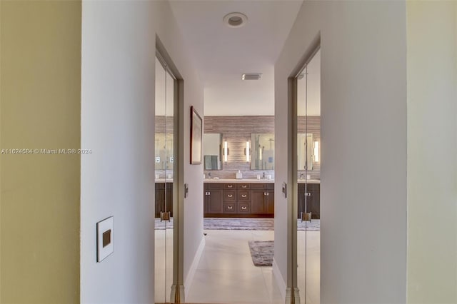 corridor with sink and light tile patterned floors