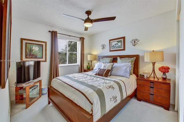 bedroom featuring a closet, a textured ceiling, light colored carpet, and ceiling fan