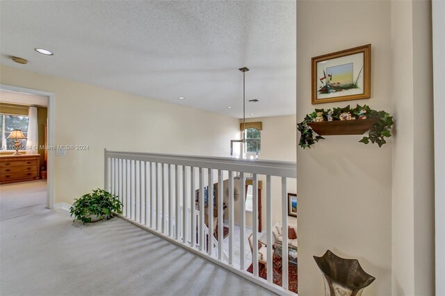 corridor featuring carpet floors and a textured ceiling