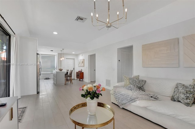 living room featuring an inviting chandelier and light hardwood / wood-style flooring