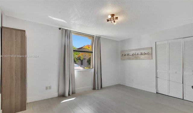 empty room featuring light hardwood / wood-style floors and a textured ceiling