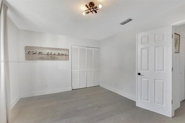 interior space with light hardwood / wood-style floors, a closet, and a textured ceiling