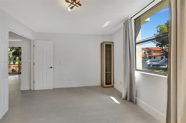 empty room featuring a textured ceiling and a wealth of natural light