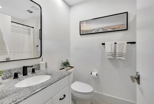 bathroom featuring vanity, toilet, and a shower with shower curtain