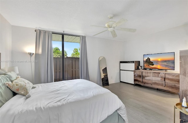 bedroom with ceiling fan, hardwood / wood-style floors, and a textured ceiling