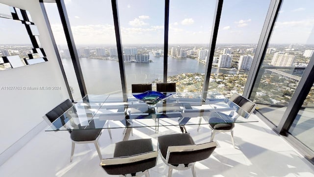 dining room with a water view, expansive windows, and plenty of natural light