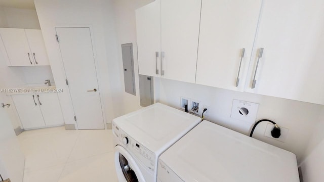 laundry room with cabinets, electric panel, light tile patterned floors, and washing machine and clothes dryer