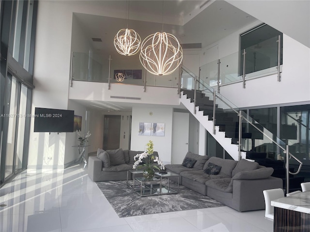 tiled living room featuring a towering ceiling and a notable chandelier