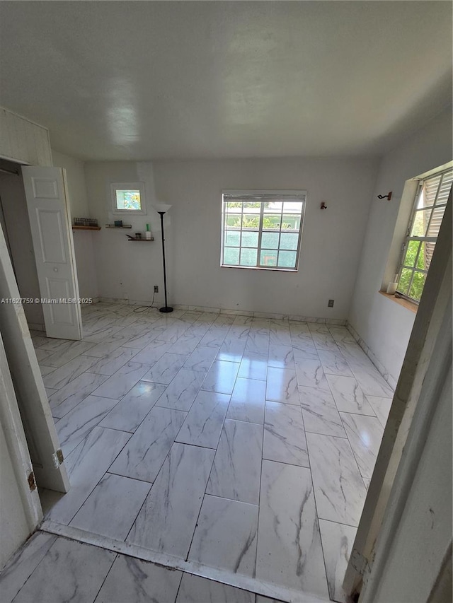 spare room featuring marble finish floor