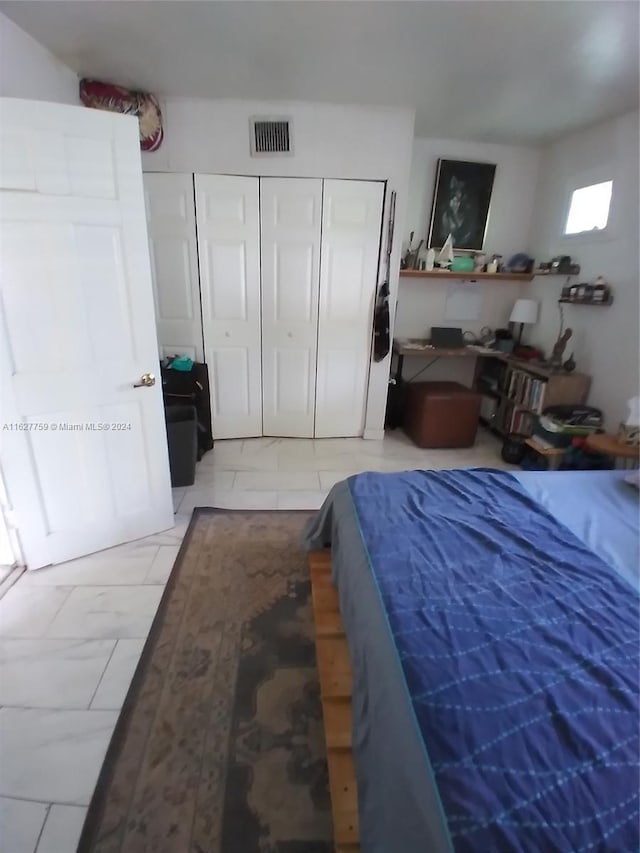 bedroom featuring a closet, visible vents, and marble finish floor