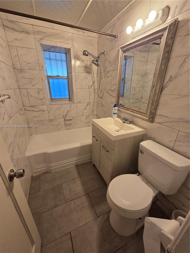 bathroom featuring toilet, vanity, tile walls, shower / tub combination, and a textured ceiling