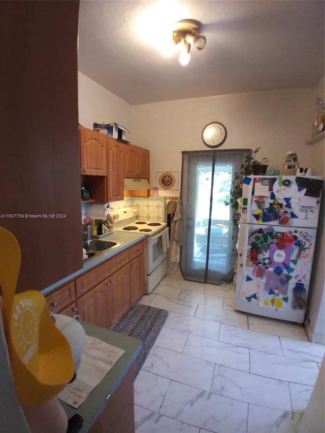 kitchen featuring white appliances, a sink, marble finish floor, light countertops, and decorative backsplash