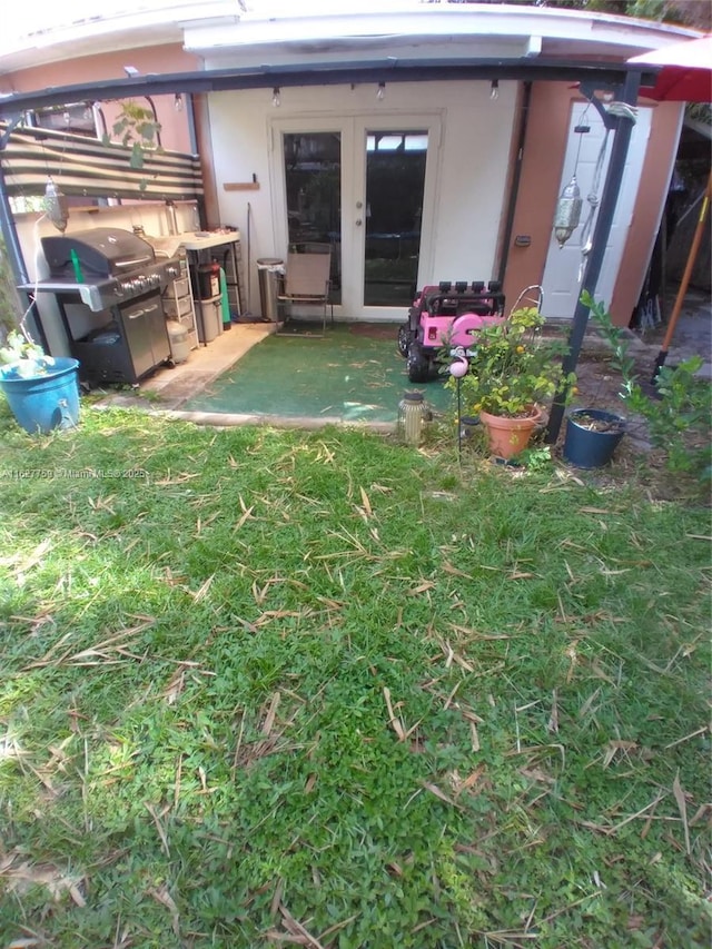 rear view of house featuring a lawn and french doors