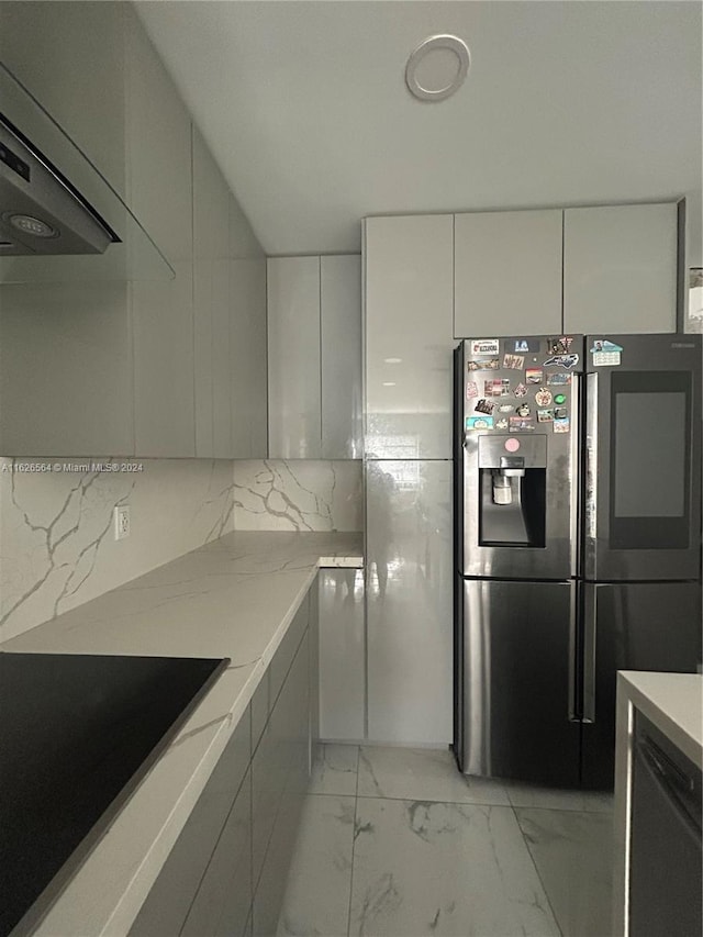 kitchen featuring light stone countertops, ventilation hood, black electric cooktop, stainless steel fridge with ice dispenser, and white cabinetry