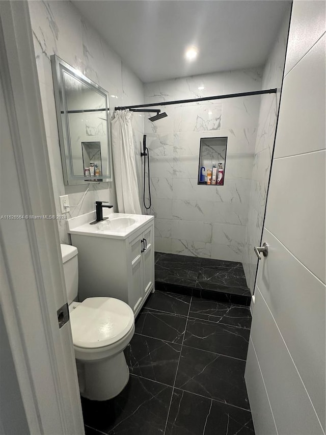 bathroom with vanity, toilet, walk in shower, and tile walls