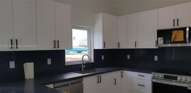 kitchen with sink, white cabinetry, appliances with stainless steel finishes, and decorative backsplash