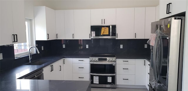 kitchen featuring sink, stainless steel appliances, white cabinetry, and decorative backsplash