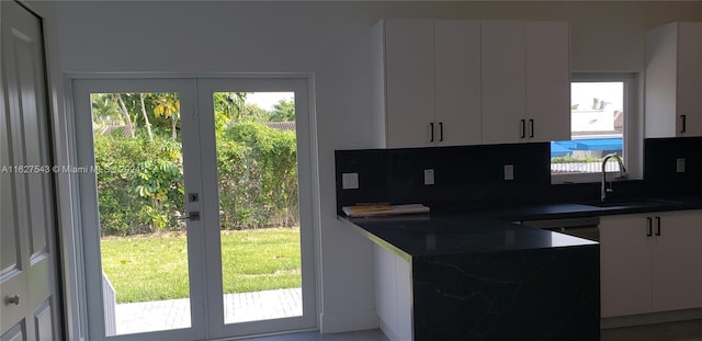 kitchen featuring sink, backsplash, and white cabinetry