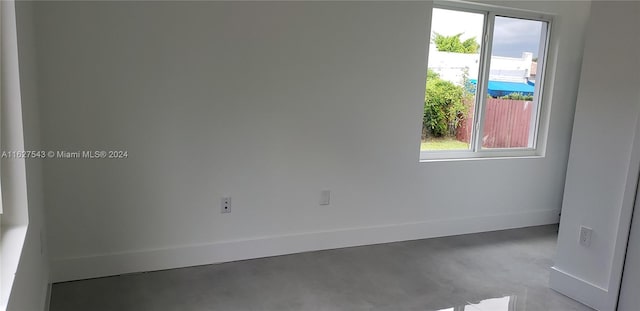 spare room featuring plenty of natural light and concrete flooring