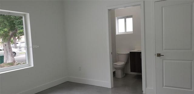 bathroom with toilet, a wealth of natural light, and vanity