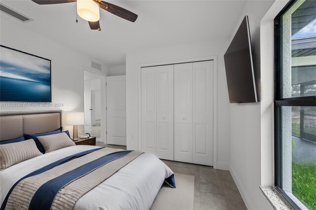 bedroom featuring multiple windows, ceiling fan, and a closet