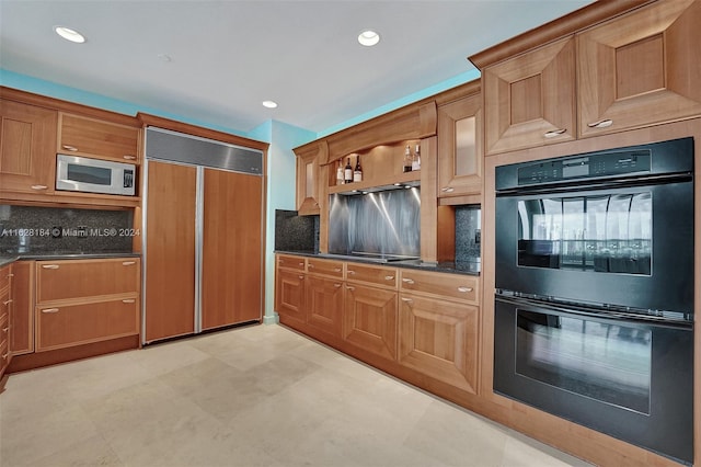 kitchen with dark stone counters, light tile patterned flooring, black appliances, and decorative backsplash