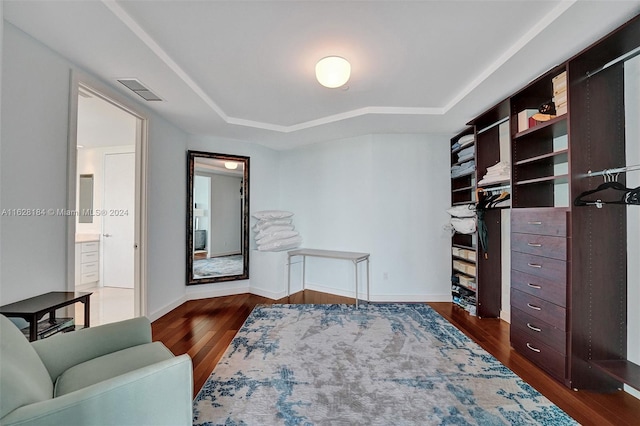 living area with dark hardwood / wood-style flooring and a raised ceiling