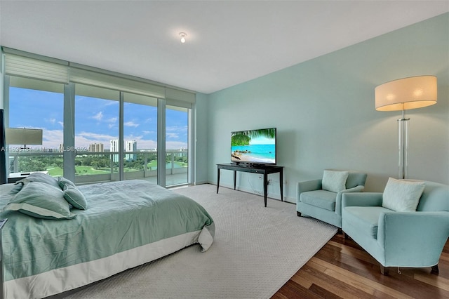 bedroom featuring dark hardwood / wood-style floors and a wall of windows