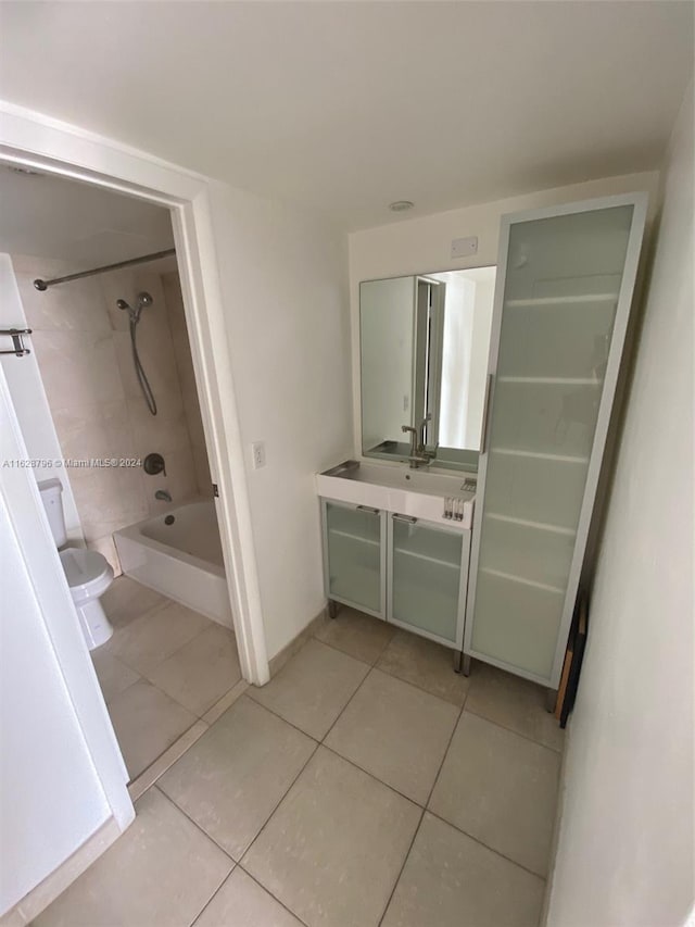 full bathroom with tiled shower / bath, vanity, toilet, and tile patterned floors