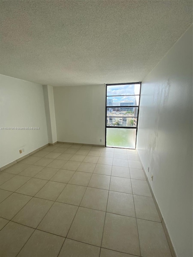 tiled spare room featuring a textured ceiling