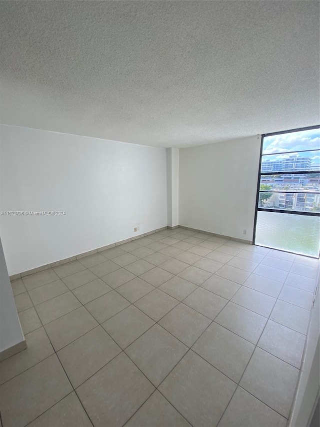 tiled empty room with a textured ceiling