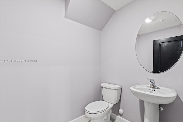 bathroom with lofted ceiling and toilet