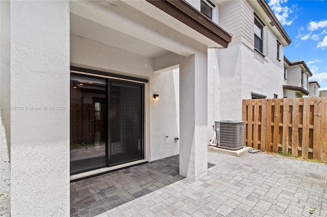 doorway to property with central AC unit and a patio