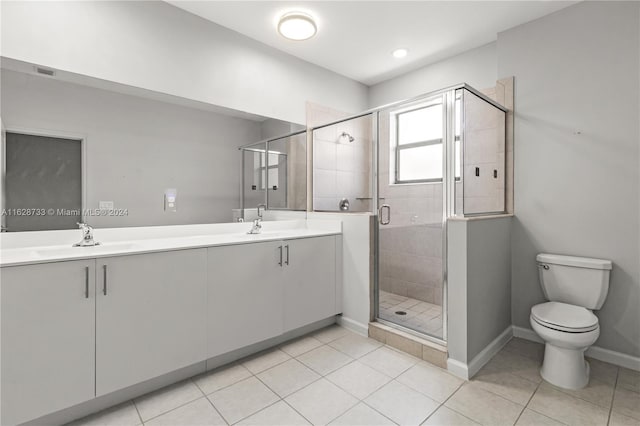 bathroom with vanity, toilet, tile patterned floors, and a shower with shower door