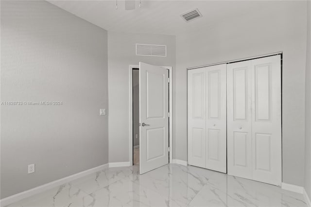 unfurnished bedroom with ceiling fan and a closet