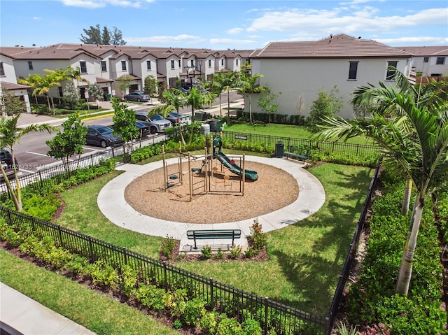 surrounding community featuring a playground and a lawn