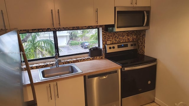 kitchen with decorative backsplash, sink, and appliances with stainless steel finishes