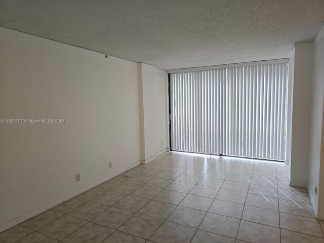 tiled empty room with a textured ceiling