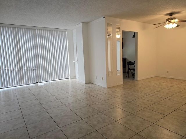 tiled spare room featuring ceiling fan, a textured ceiling, and ornamental molding